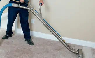 Professional operating a liquid removal machine on a carpeted floor in Bakersfield, CA
